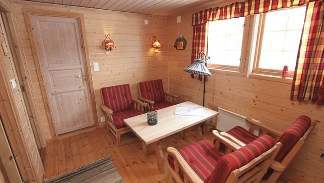 Stue på hytte med stoler og bord